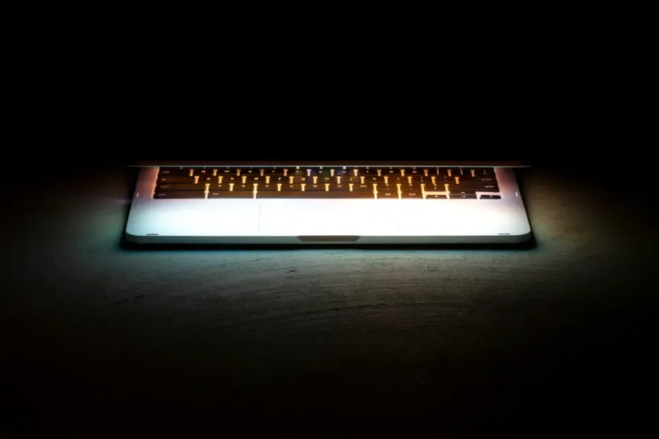 Notebook com teclado iluminado em ambiente escuro